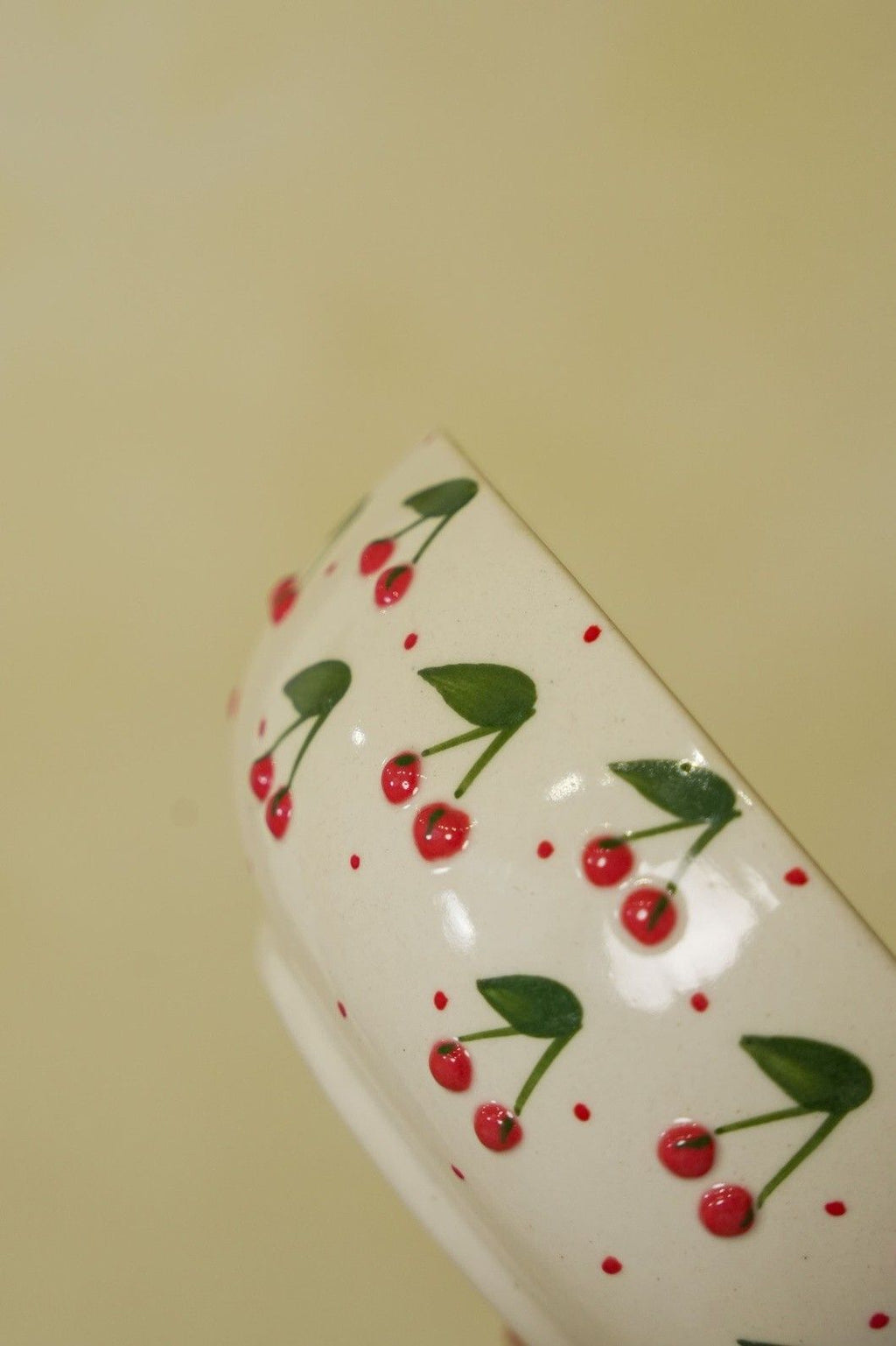 White container with red cherry design on a beige background