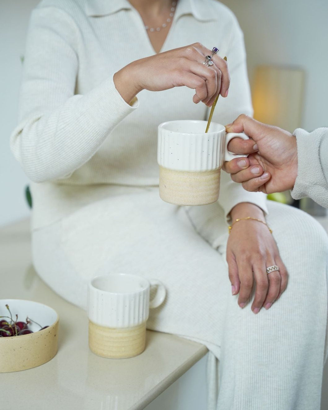 Two people sharing a cup of coffee in a cozy setting.