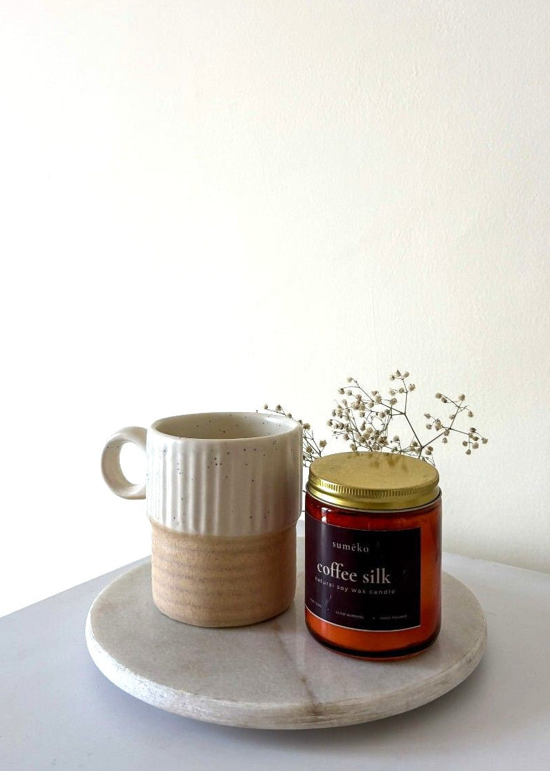 sumeko Ceramic mug and candle on a marble tray with a white background