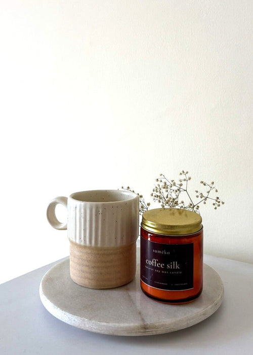 sumeko Ceramic mug and candle on a marble tray with a white background