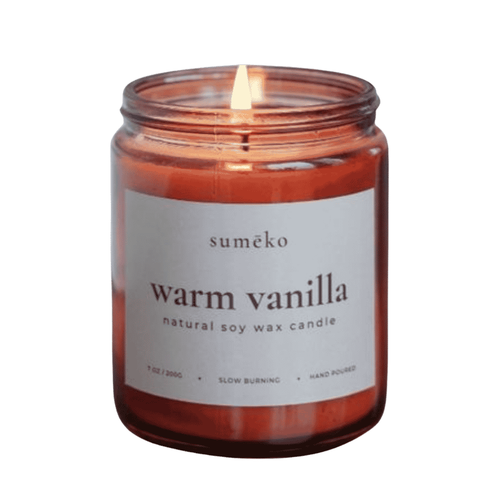 Suméko warm vanilla candle in a glass jar with a label on a green background