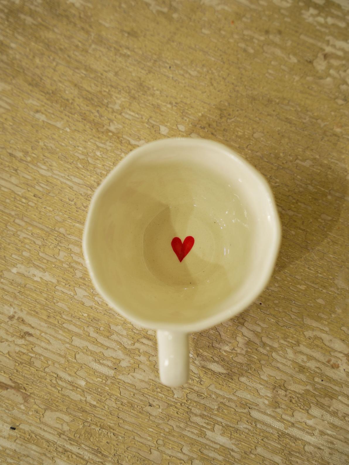 Ceramic mug with a red heart design on the inside.