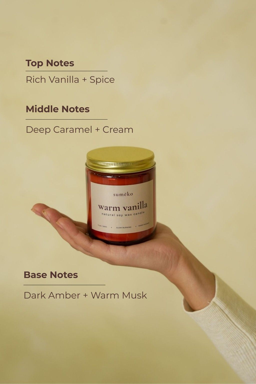 Hand holding a candle labeled 'warm vanilla' with notes displayed on a beige background